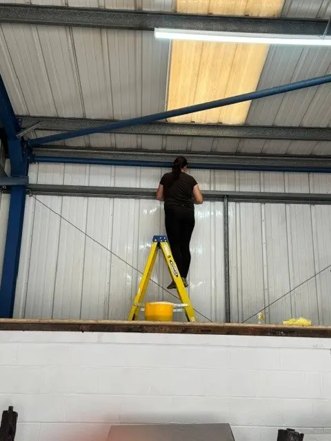 Operative carrying out high-level cleaning inside a commercial unit